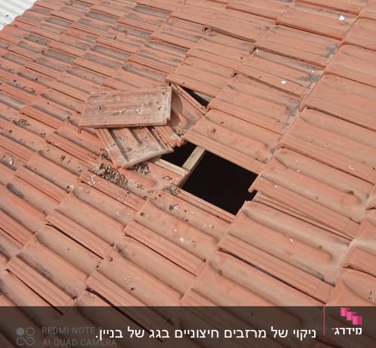 רעפים שבורים על גג עם חור חשוף